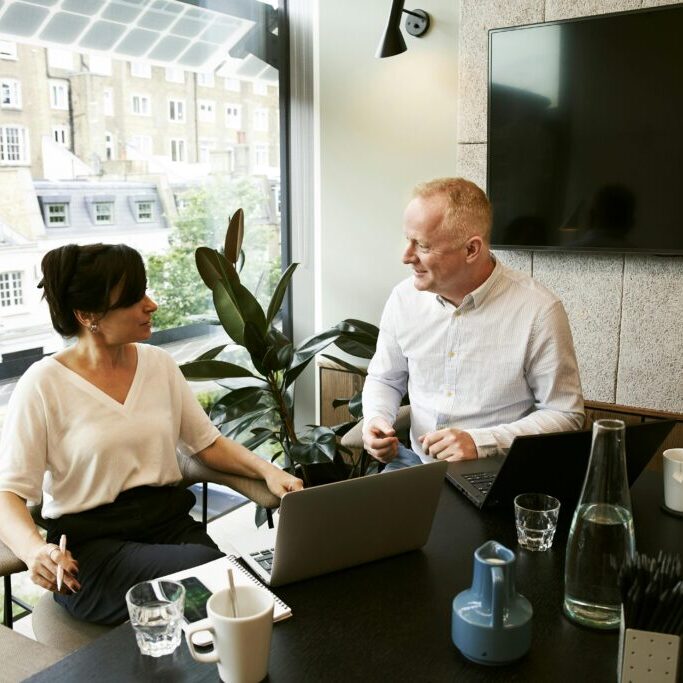 A middle-aged man and woman sitting down to discuss ideas